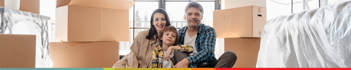 A family sitting in their new home surrounded by moving boxes