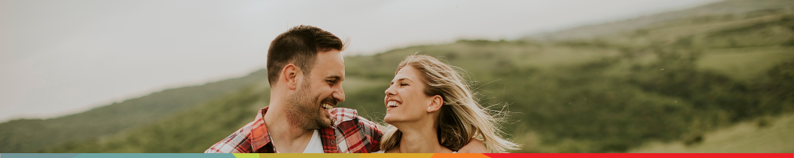 couple smiling at each other on vacation because of their financial plan