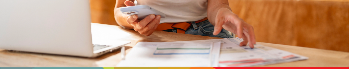 A woman at the computer calculating how to save money through saving and investing